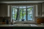 Large windows by the kitchen sink overlooking the lake